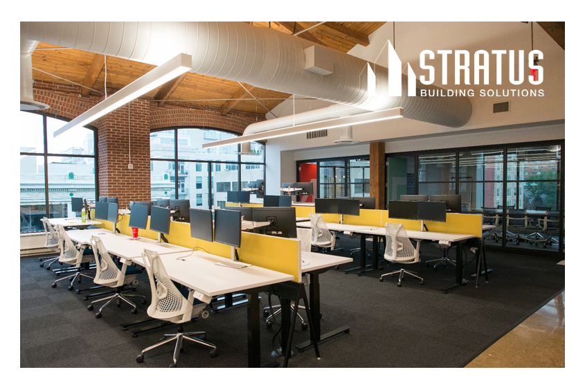 A pristine office with white tables, chairs, monitors, and yellow partitions that has been professionally cleaned.