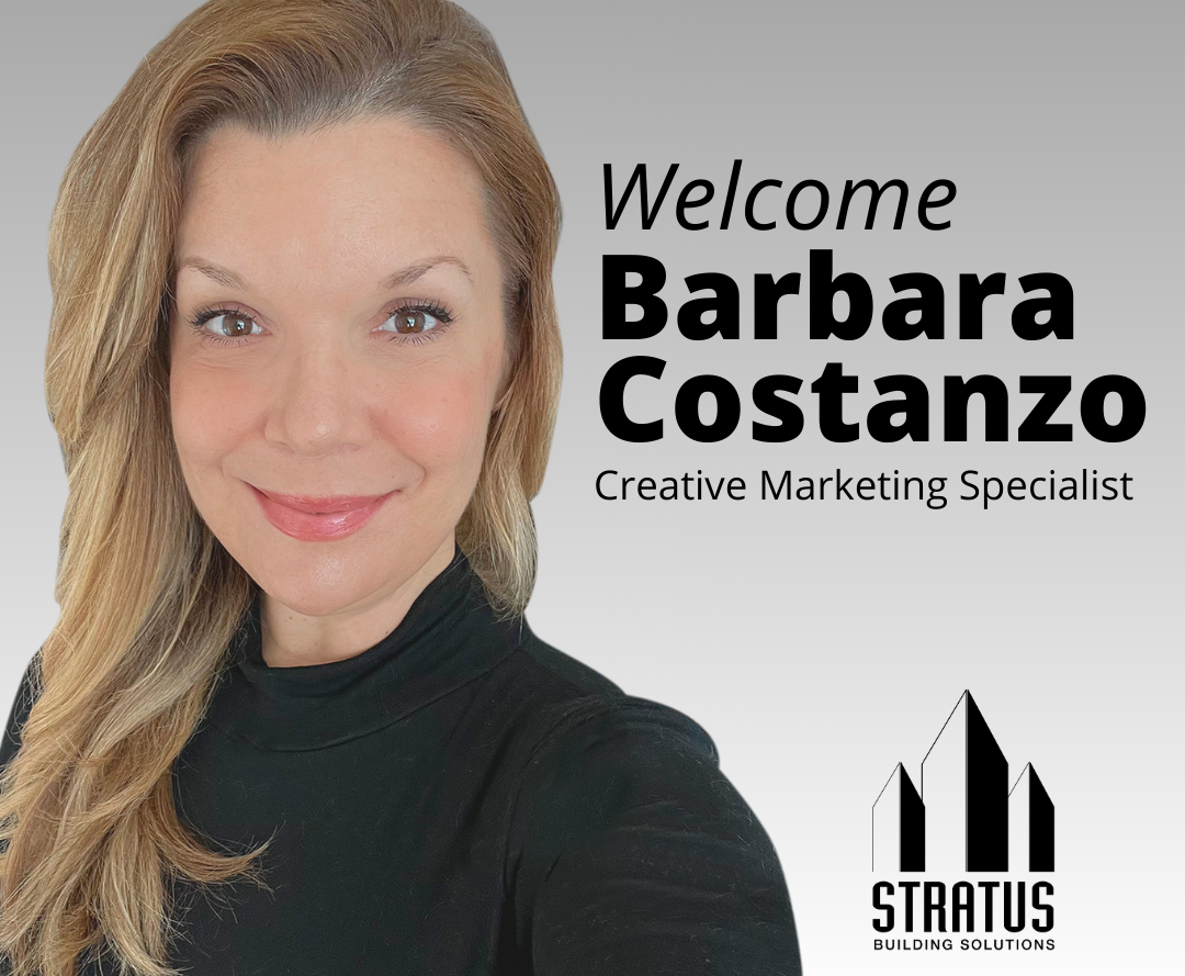 Barbara Costanzo with Blurry White and Gray Office Foyer in the Background